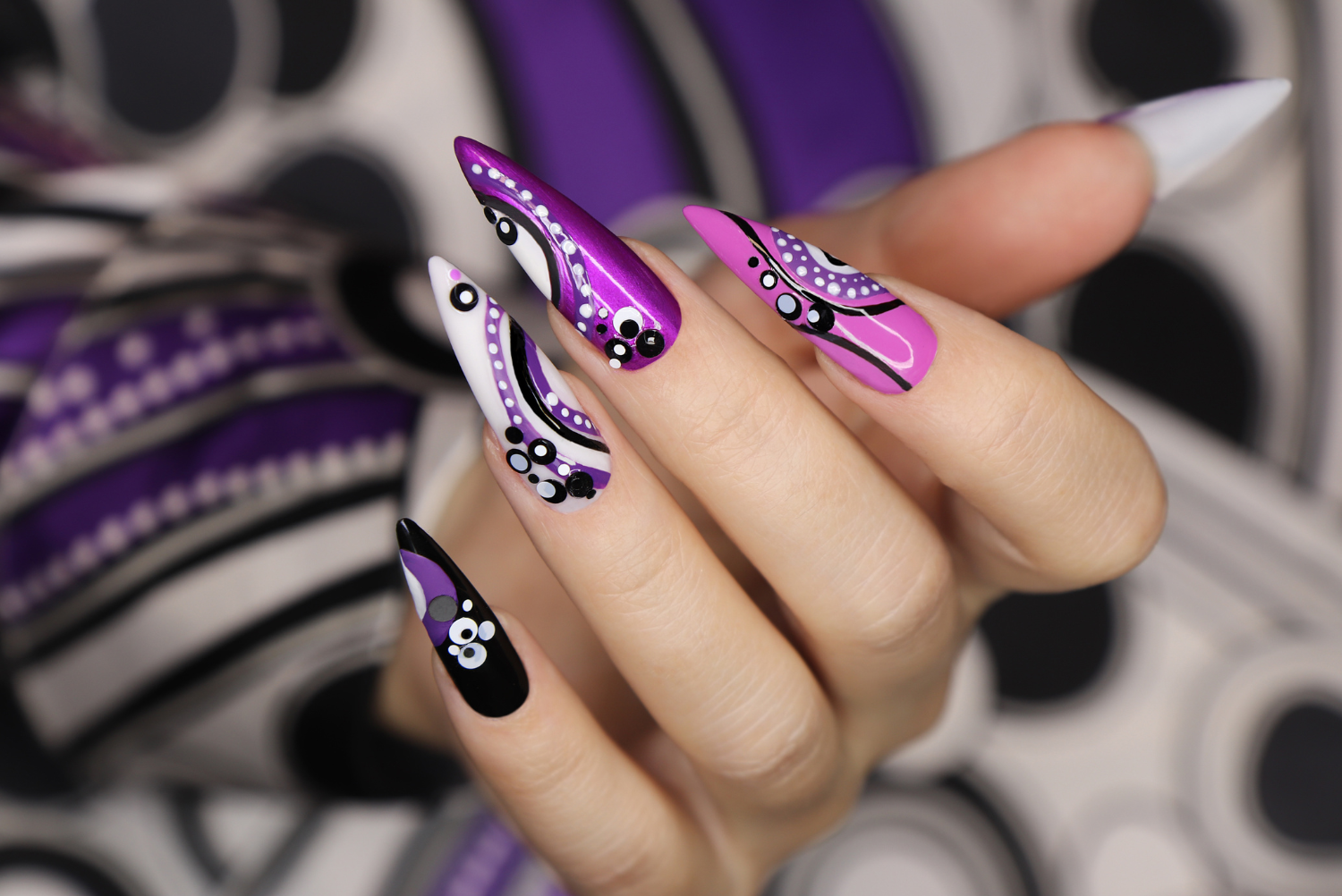 a person with long pink and purple painted nails